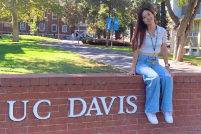 Student is posing with the University logo.