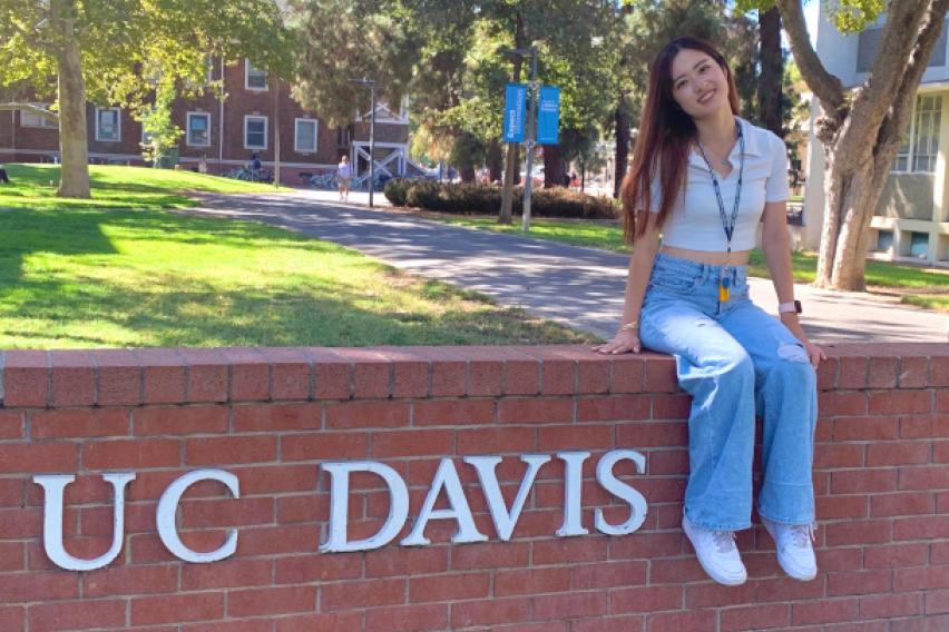 Student is posing with the University logo.