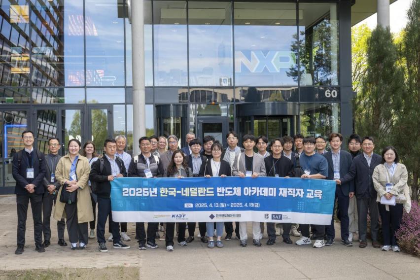 A group of Korean semiconductor professionals stand with an SAF banner in Amsterdam