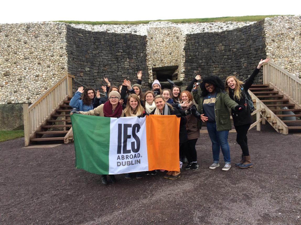 a group of students pose with an IES Abroad Dublin flag