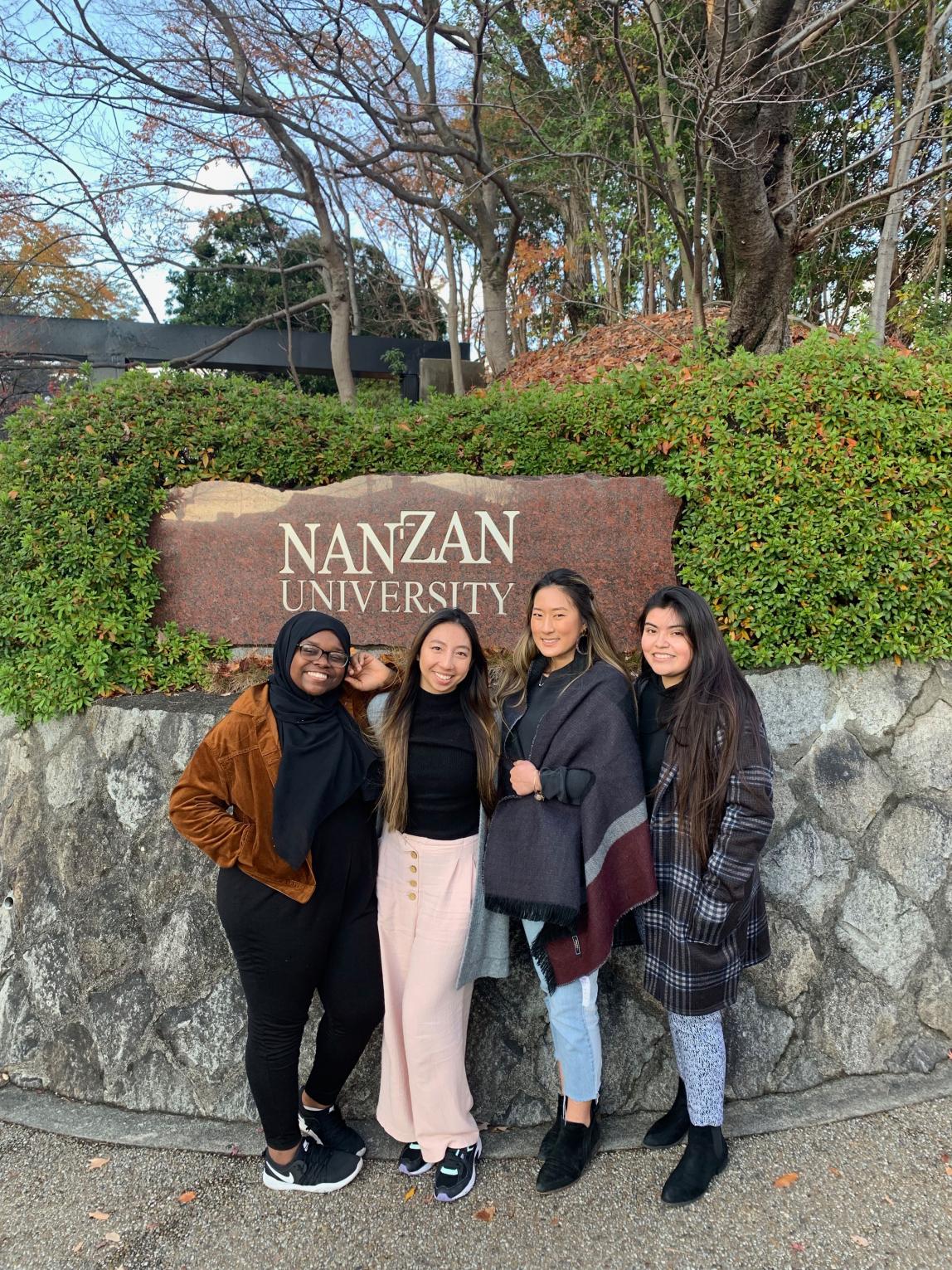 students pose for a photo in front of the Nanzan University sign in Nagoya