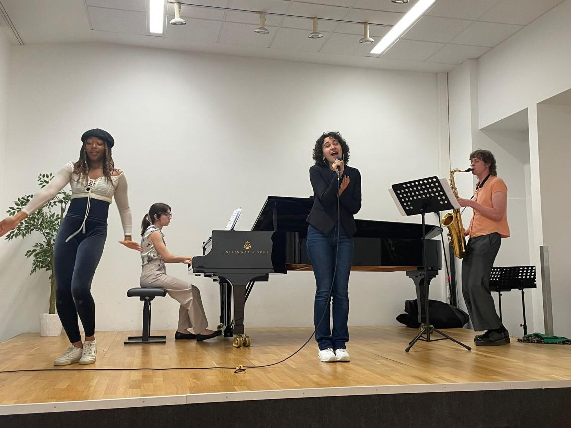 four students on a stage performing music
