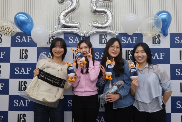 SAF校友活动 - 学生在25周年庆典横幅前