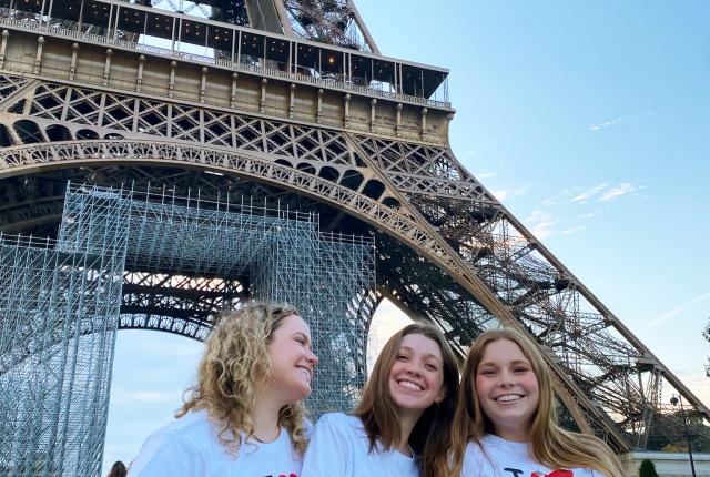 three female students having fun at the Eiffel Tower