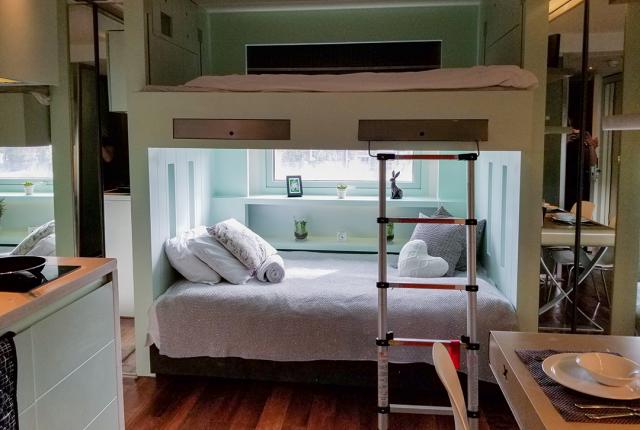 A clean double bunk bed sitting in the hallway between living spaces.