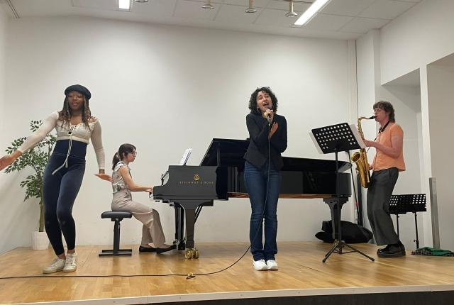 four students on a stage performing music