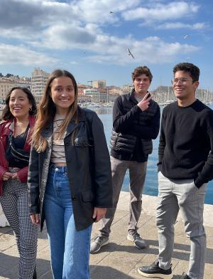 students laughing in front of water and buildings