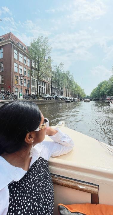 a student riding through the Amsterdam canals on a boat