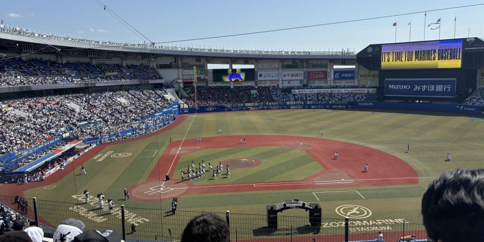 A baseball field and game as seen from the stands.